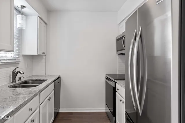 a kitchen with stainless steel appliances granite countertop a refrigerator and a sink