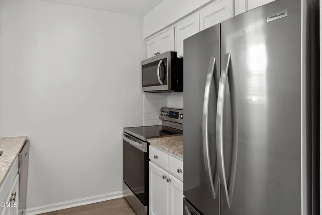 a kitchen with stainless steel appliances granite countertop a refrigerator and a stove