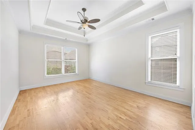 a view of an empty room with a window and wooden floor
