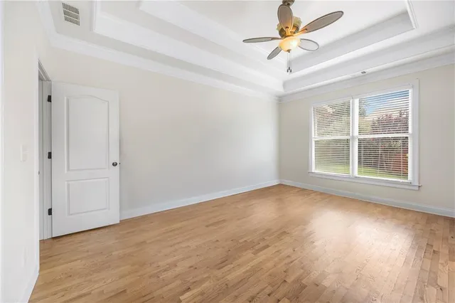 a view of an empty room with window and wooden floor