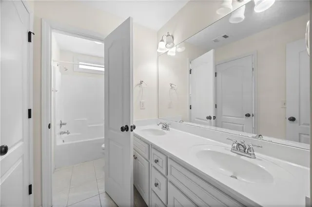a bathroom with double vanity sinks and a mirror