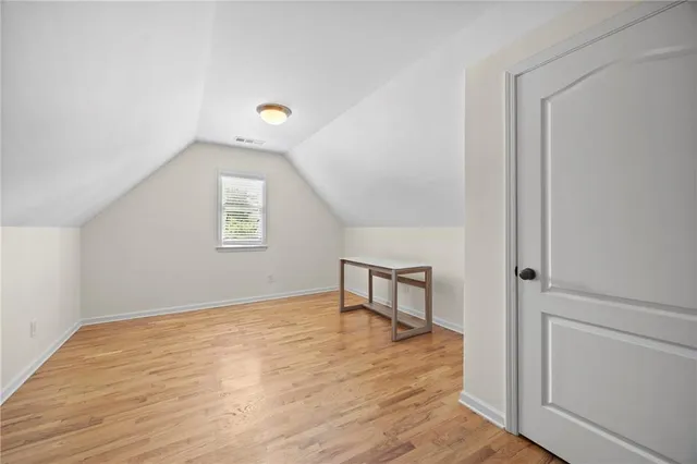 a view of a livingroom with wooden floor and a hallway
