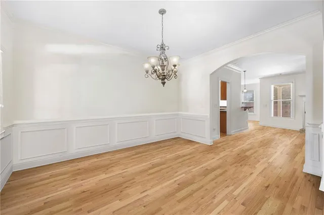a view of a room with wooden floor and chandelier
