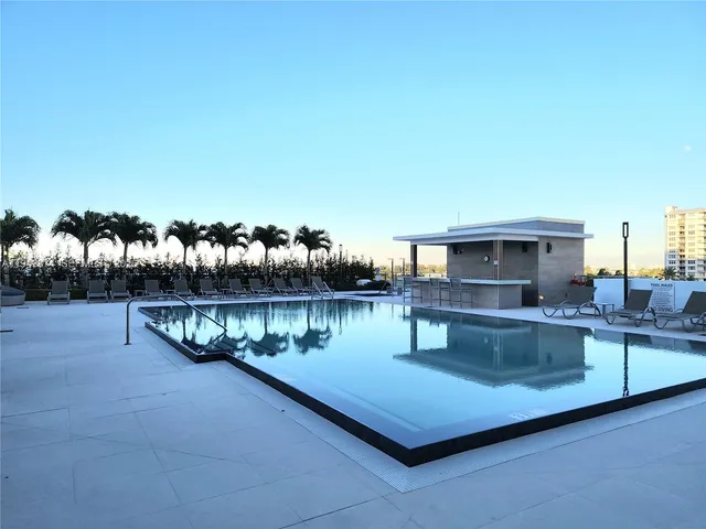 a roof deck with couches and potted plants
