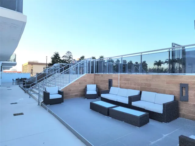 a view of a lake from a balcony with seating space