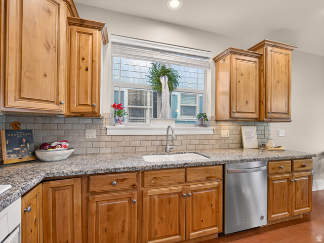 557 Craftsman Way Midway, UT 84049 - Photo 20 of 59 Kitchen featuring a double basin sink, granite countertops, wood cabinetry, subway tile backsplash, and a stainless steel dishwasher