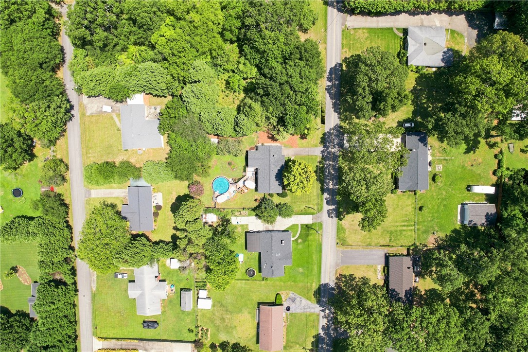 204 Sylvia Road Easley, SC 29642 - Photo 34 of 36 An aerial perspective reveals a residential area with multiple homes, mature trees, and private pools dotting the verdant landscape.