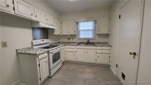 a kitchen with granite countertop cabinets and white appliances