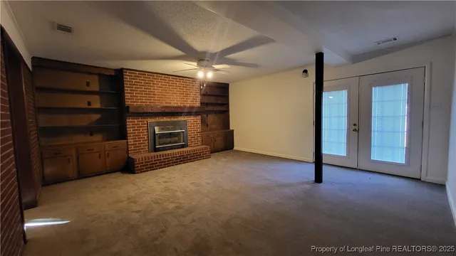 a view of an empty room with a fireplace and a window