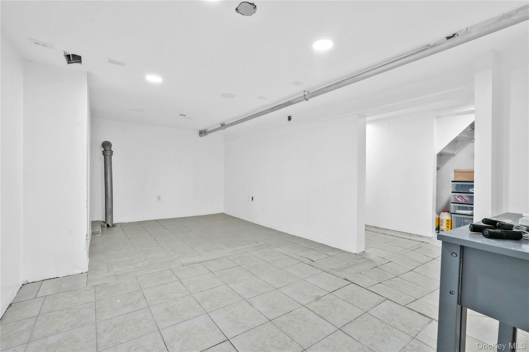 80-63 87th Road Queens, NY 11421 - Photo 13 of 50 Unfurnished basement room with light tile patterned floors and recessed lighting