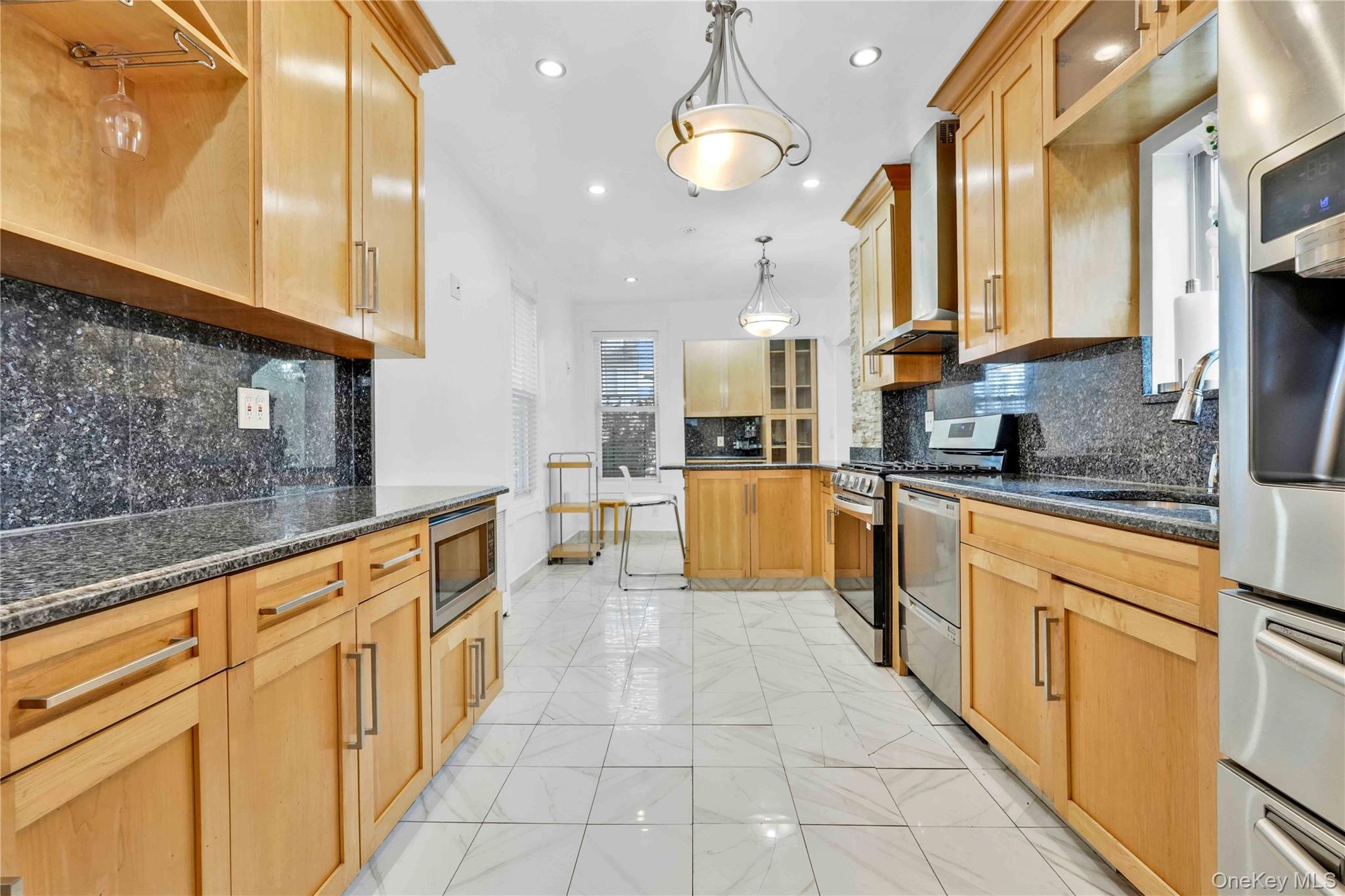 80-63 87th Road Queens, NY 11421 - Photo 19 of 50 Kitchen featuring glass insert cabinets, pendant lighting, appliances with stainless steel finishes, recessed lighting, and dark stone counters