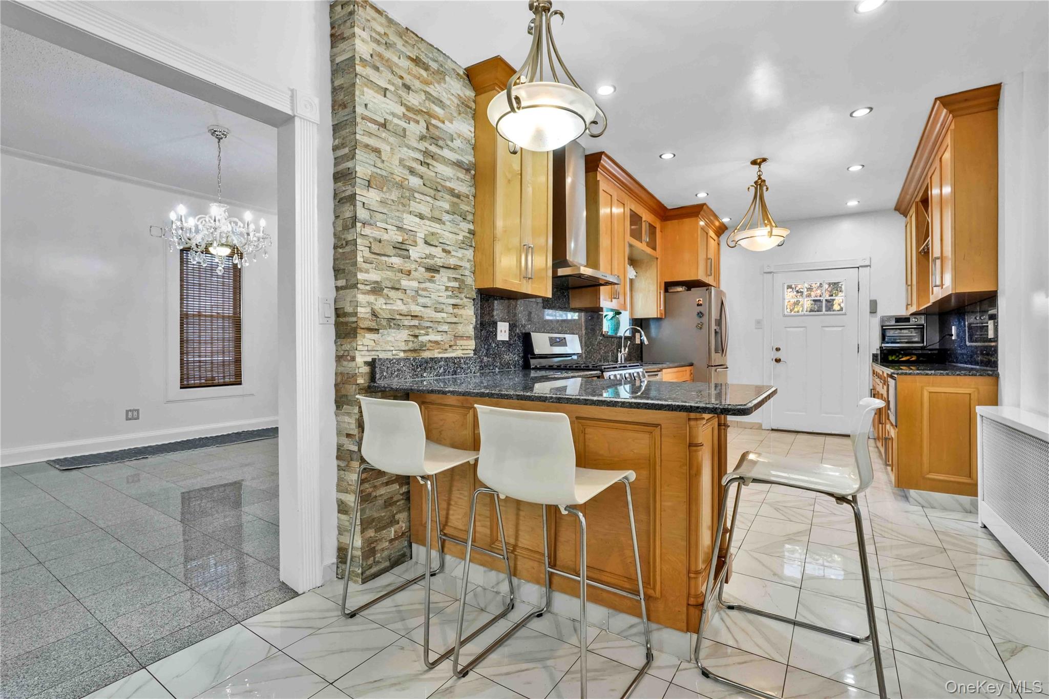 80-63 87th Road Queens, NY 11421 - Photo 21 of 50 Kitchen with dark stone counters, a breakfast bar, decorative backsplash, pendant lighting, and stainless steel appliances