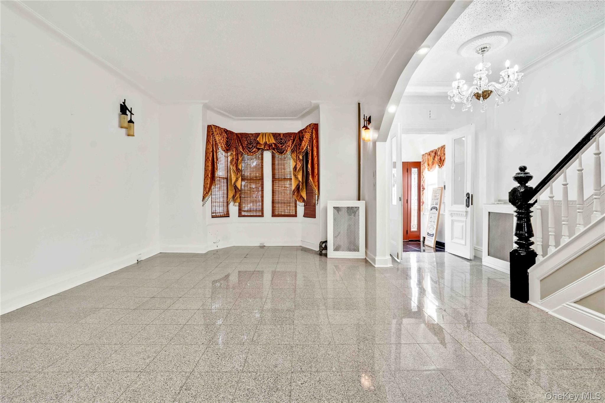 80-63 87th Road Queens, NY 11421 - Photo 30 of 50 Entryway featuring granite floors, ornamental molding, arched walkways, a chandelier, and stairs