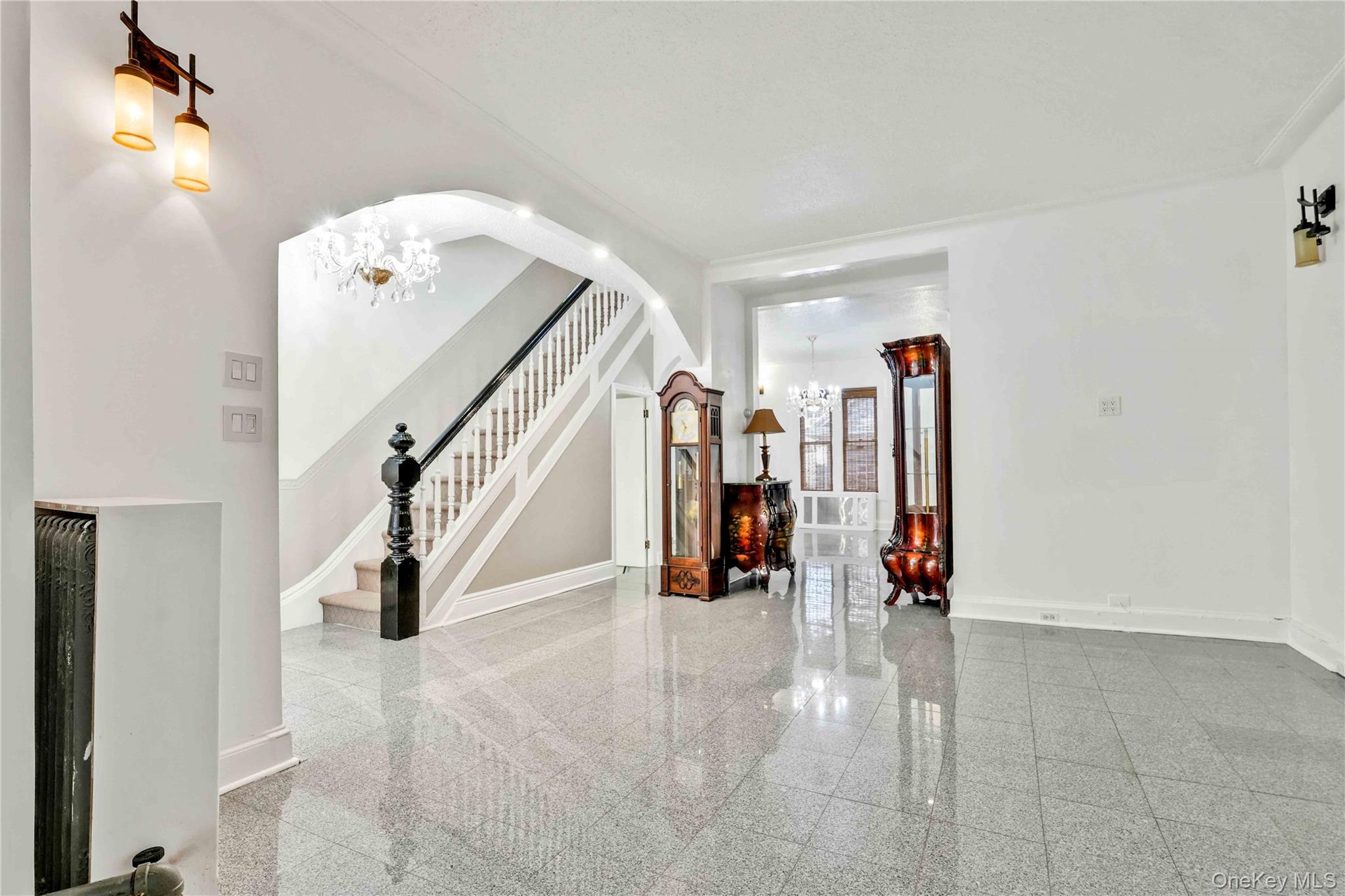 80-63 87th Road Queens, NY 11421 - Photo 32 of 50 Entryway with a chandelier, granite tiled floors, arched walkways, and stairway
