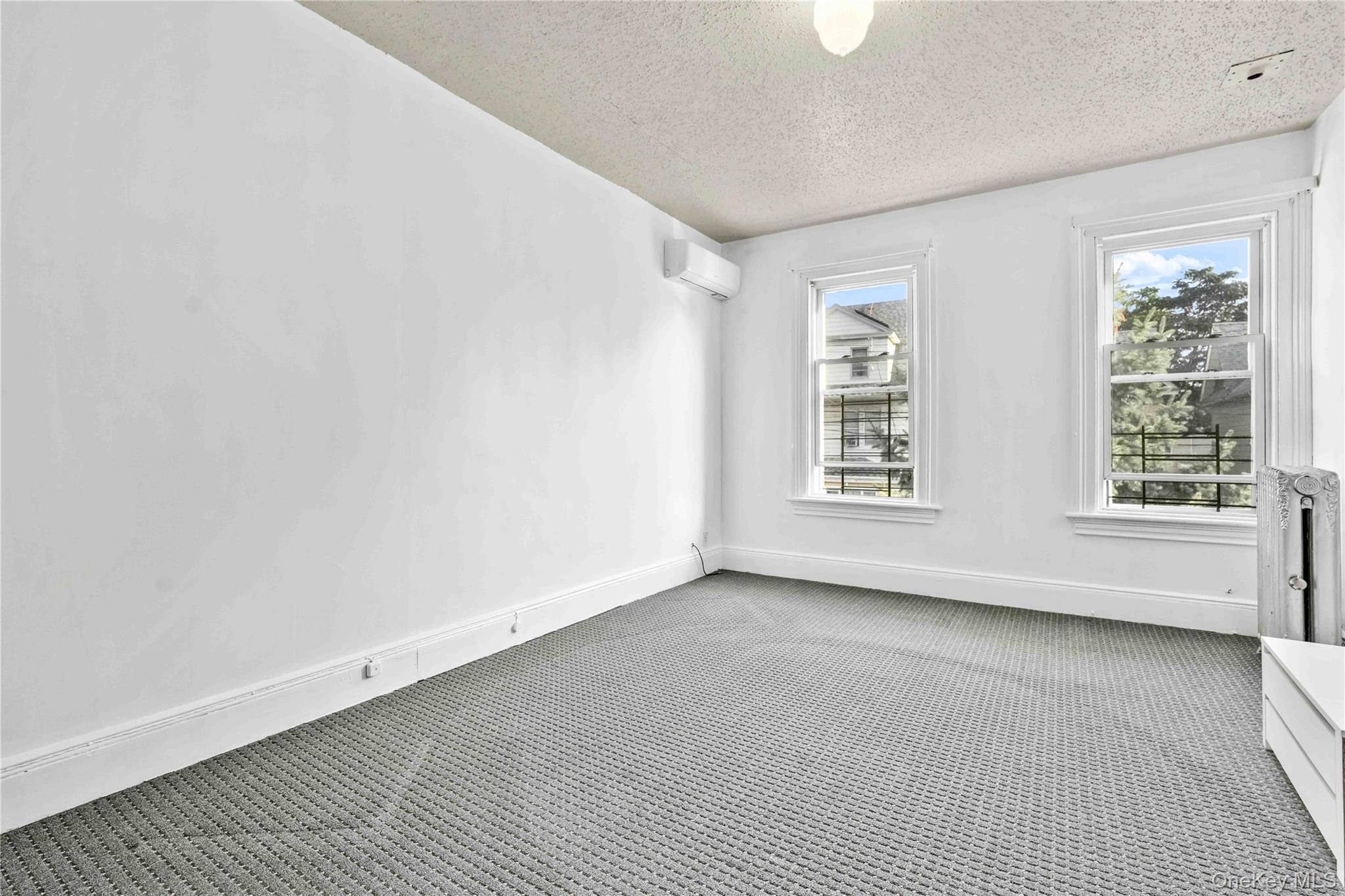 80-63 87th Road Queens, NY 11421 - Photo 33 of 50 bedroom with carpet floors, a textured ceiling, and an AC wall unit