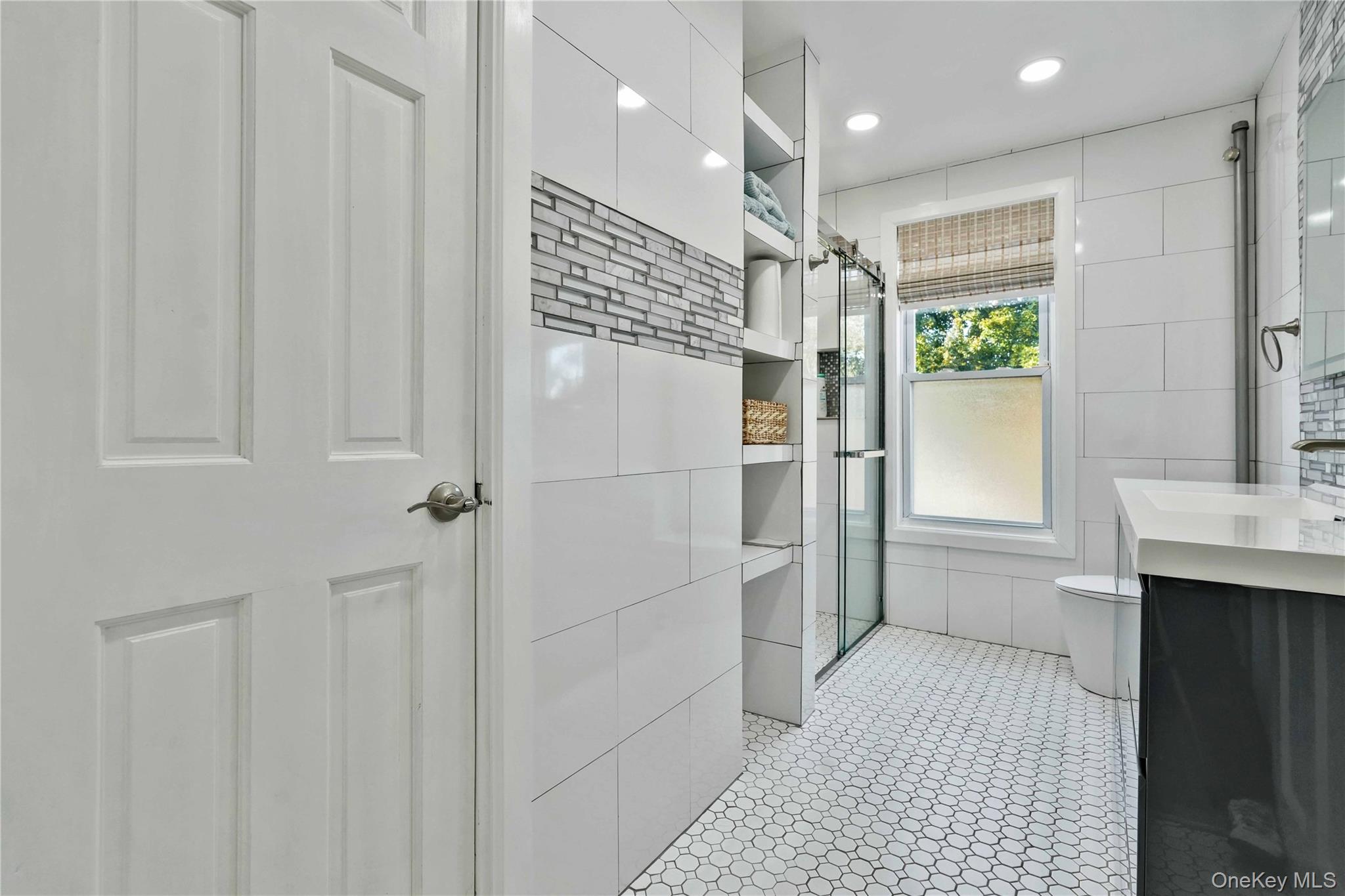 80-63 87th Road Queens, NY 11421 - Photo 40 of 50 Full main bathroom featuring vanity, tile walls, a stall shower, light tile patterned floors, and recessed lighting