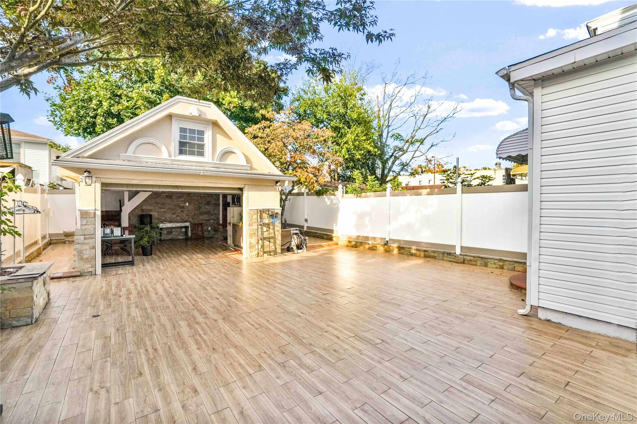 80-63 87th Road Queens, NY 11421 - Photo 9 of 50 Fenced backyard with a garage and a patio area