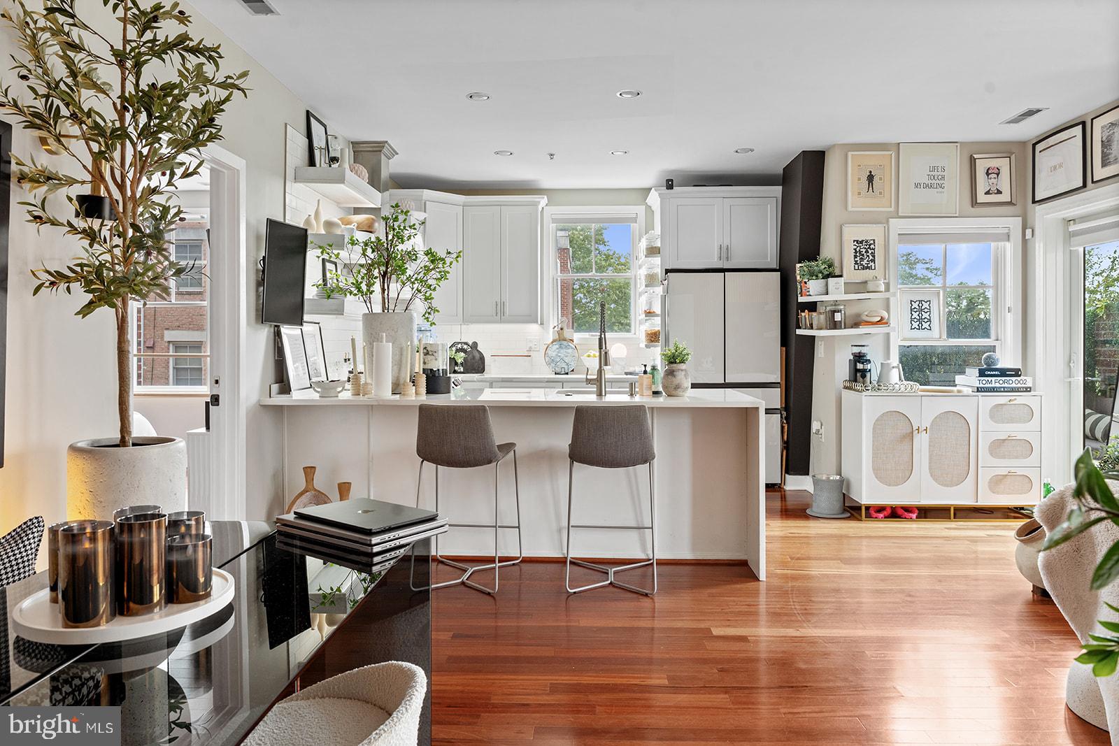 181 East Reed Avenue, Unit 207 Alexandria, VA 22305 - Photo 12 of 41 a kitchen with stainless steel appliances kitchen island granite countertop a stove a refrigerator a sink a dining table and chairs with wooden floor