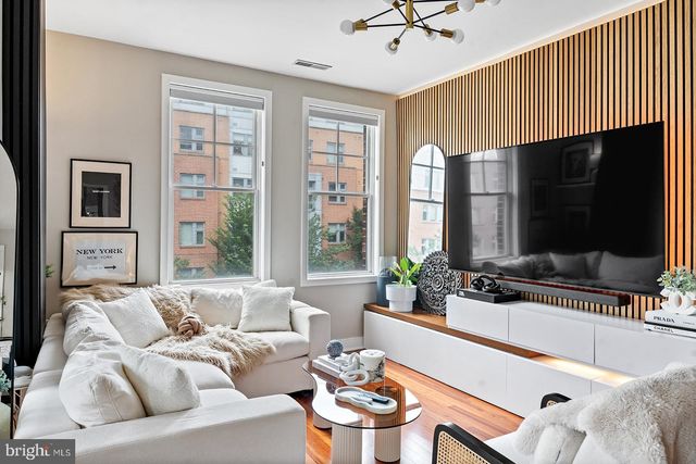 a living room with furniture a potted plant and a wooden floor