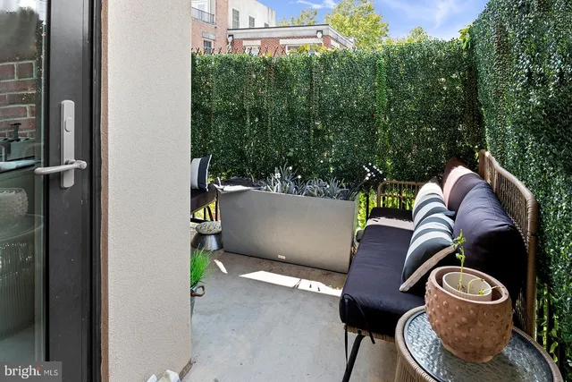 a balcony with couch and a potted plant