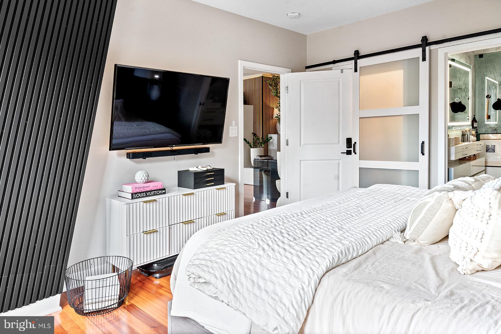 181 East Reed Avenue, Unit 207 Alexandria, VA 22305 - Photo 29 of 41 a bedroom with a bed and a flat screen tv