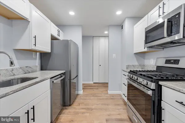 a kitchen with stainless steel appliances granite countertop a refrigerator stove and sink