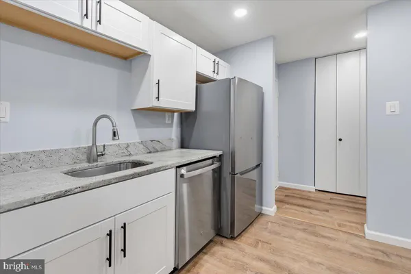 a kitchen with stainless steel appliances granite countertop a refrigerator and a sink
