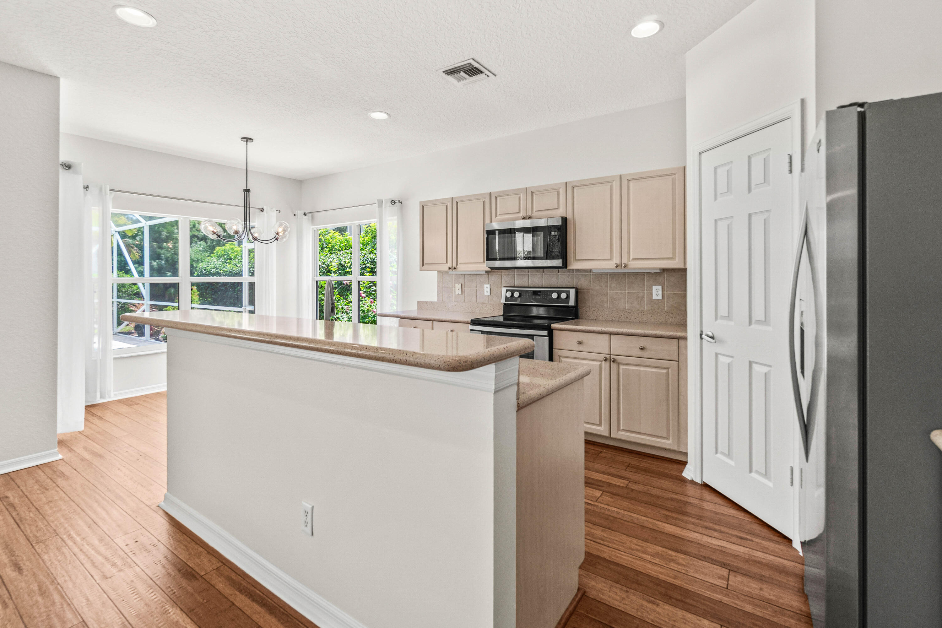 207 Pennock Trace Drive Jupiter, FL 33458 - Photo 12 of 48 a kitchen with kitchen island white cabinets and refrigerator