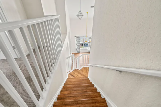 a view of a hallway with wooden floor and staircase