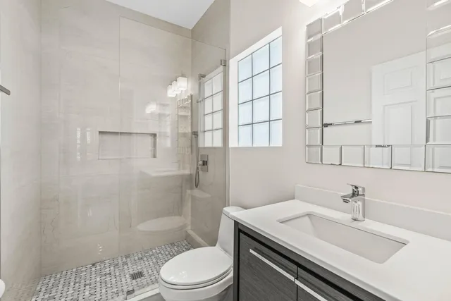 a bathroom with a sink a toilet and shower