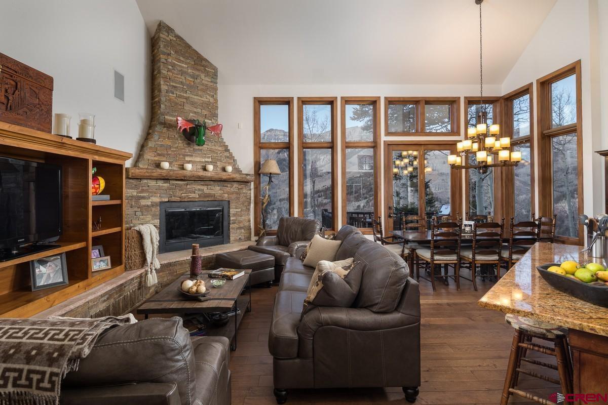 210 Sunny Ridge Place, Unit 12 Mountain Village, CO 81435 - Photo 1 of 1 a living room with furniture a fireplace and floor to ceiling window