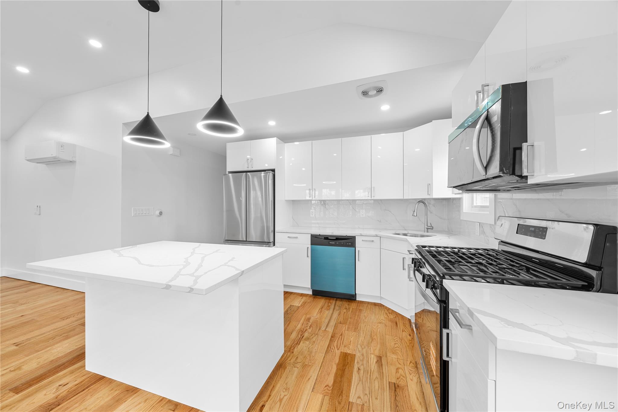 245-33 147th Road, Unit 2 Queens, NY 11422 - Photo 4 of 17 a kitchen with stainless steel appliances granite countertop a sink a stove a refrigerator and island with wooden floor