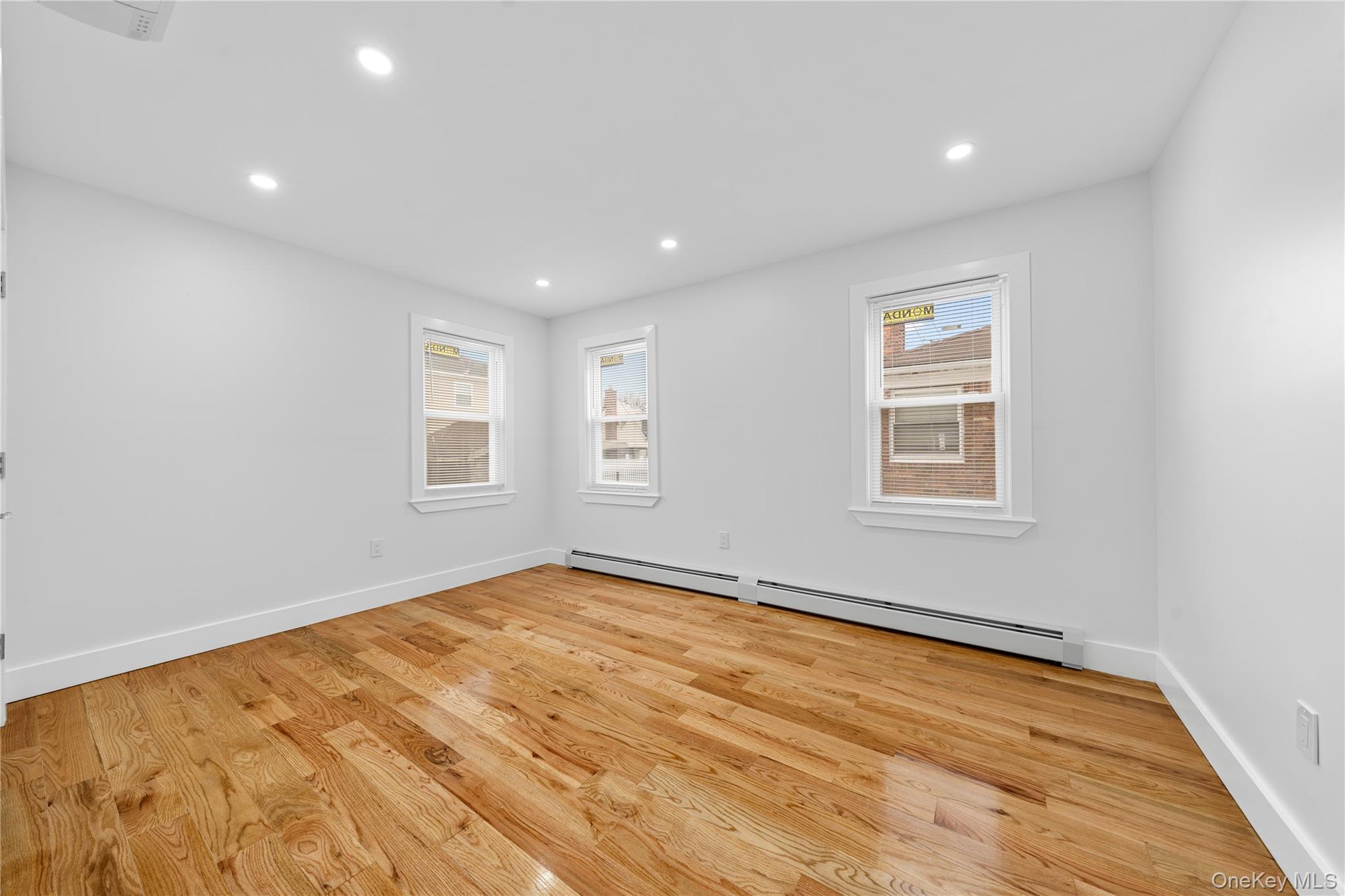 245-33 147th Road, Unit 2 Queens, NY 11422 - Photo 8 of 17 a view of an empty room with wooden floor and a window