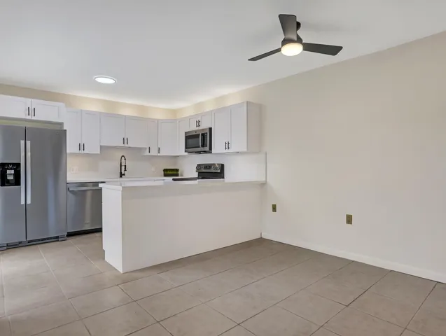 a kitchen with cabinets stainless steel appliances and a sink