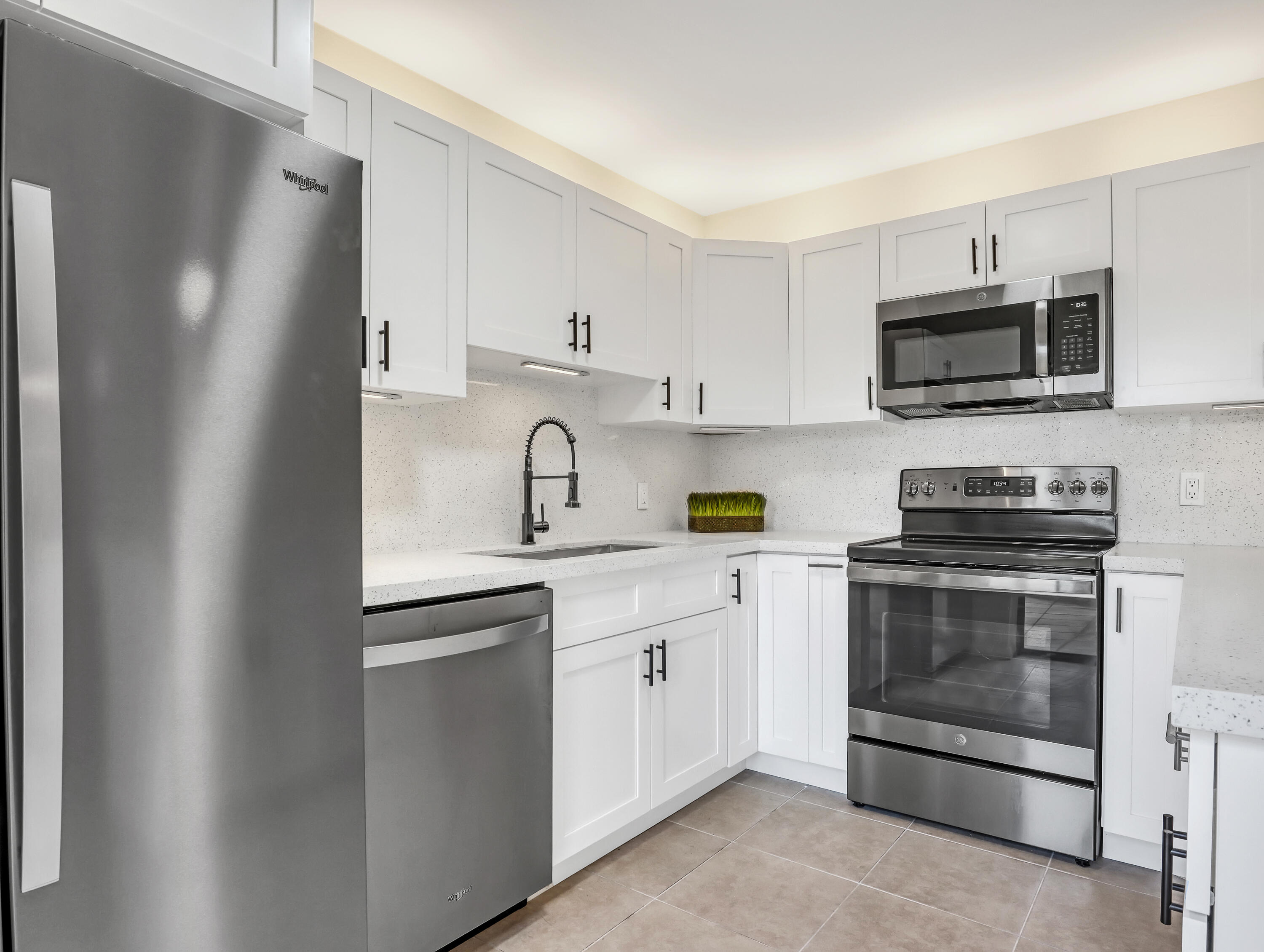 5738 Southeast Windsong Lane, Unit 315 Stuart, FL 34997 - Photo 14 of 32 a kitchen with cabinets stainless steel appliances and a sink