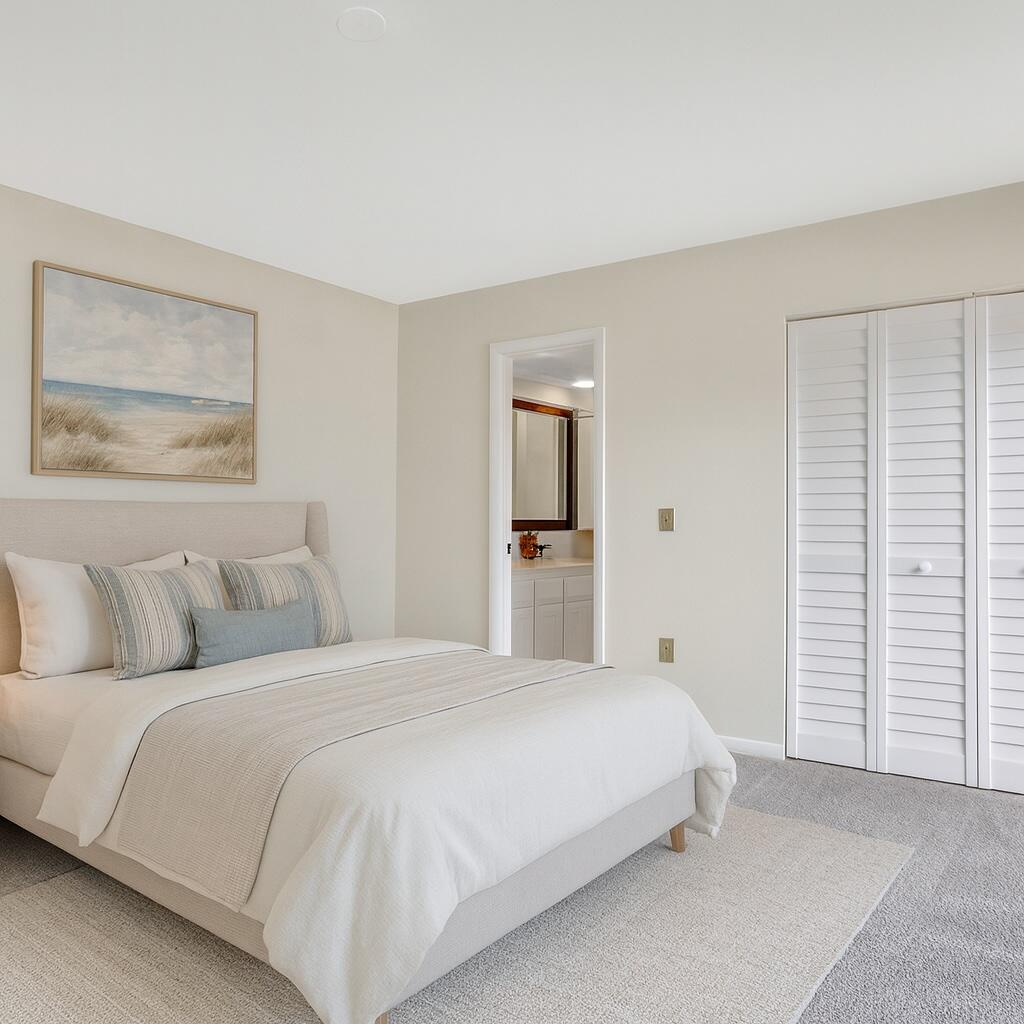 5738 Southeast Windsong Lane, Unit 315 Stuart, FL 34997 - Photo 18 of 32 a bedroom with a bed and a walk in closet