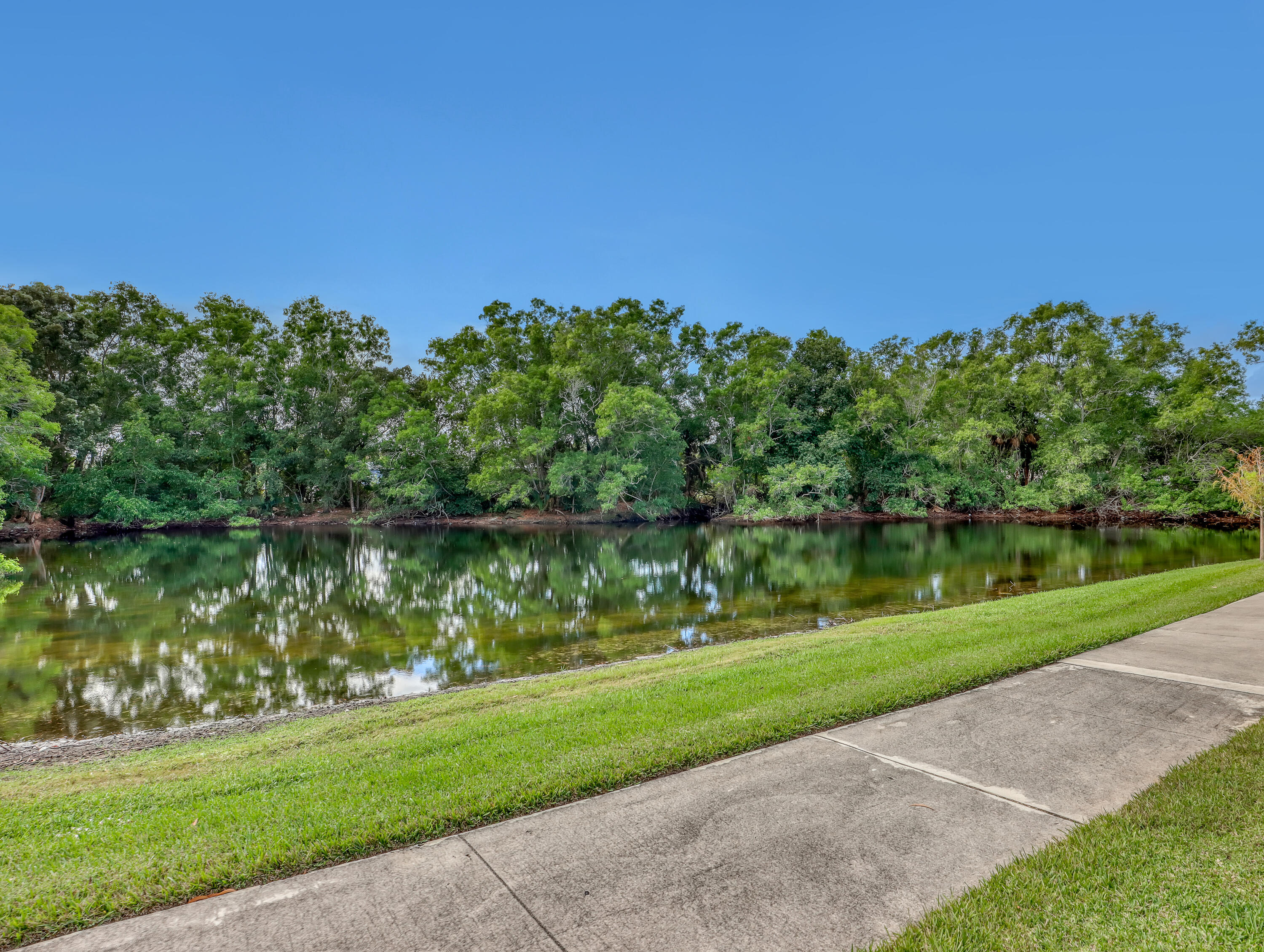5738 Southeast Windsong Lane, Unit 315 Stuart, FL 34997 - Photo 28 of 32 a view of a lake with a big yard
