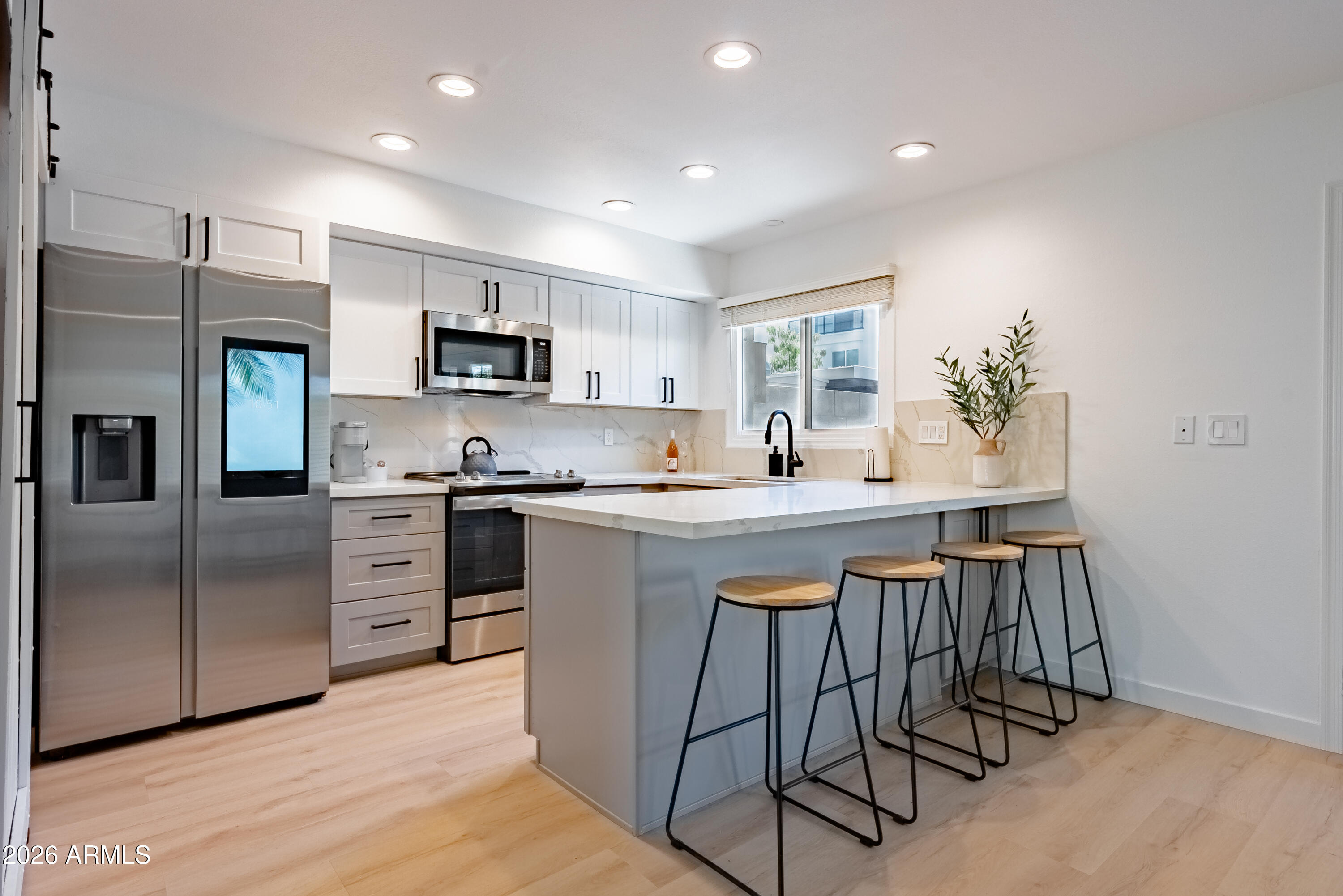 a kitchen with stainless steel appliances granite countertop a stove a sink a refrigerator and a microwave