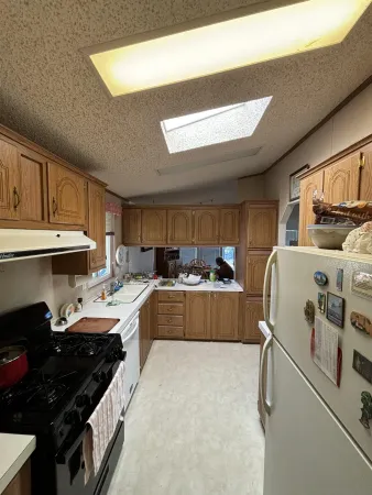 a kitchen with granite countertop a sink stove and cabinets