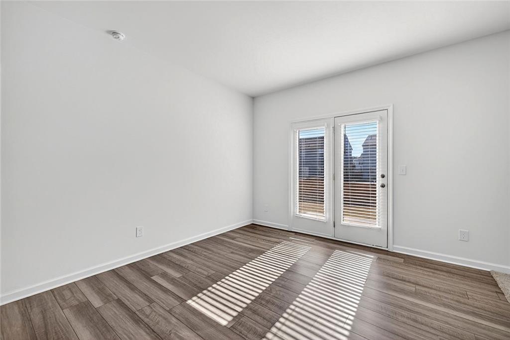 214 Georgian Way Locust Grove, GA 30248 - Photo 11 of 31 an empty room with wooden floor and windows