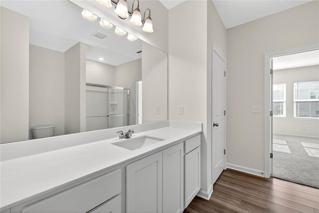 214 Georgian Way Locust Grove, GA 30248 - Photo 16 of 31 a bathroom with a sink a light fixture and a mirror