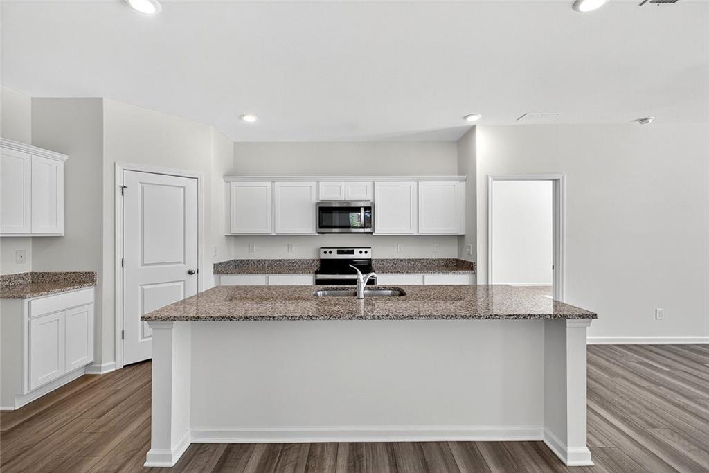 214 Georgian Way Locust Grove, GA 30248 - Photo 9 of 31 a kitchen with stainless steel appliances granite countertop a sink and a stove