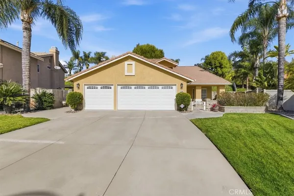 a front view of a house with a yard and potted plants