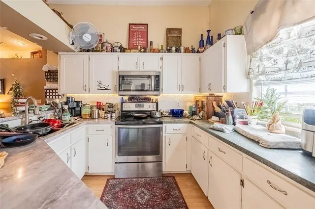 a kitchen with stainless steel appliances a sink a stove and cabinets