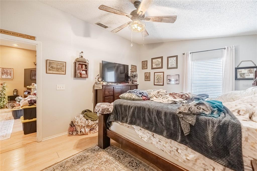 463 Emerald Cove Loop Lakeland, FL 33813 - Photo 18 of 30 a bedroom with a large bed and a chandelier