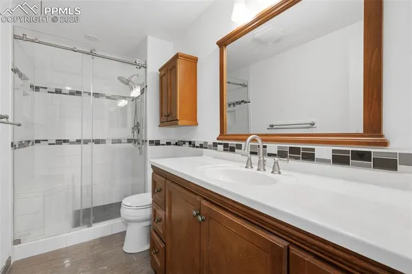 a bathroom with a granite countertop sink a toilet and a mirror