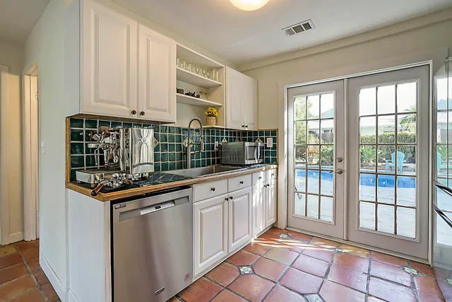 a kitchen with granite countertop a stove sink and cabinets