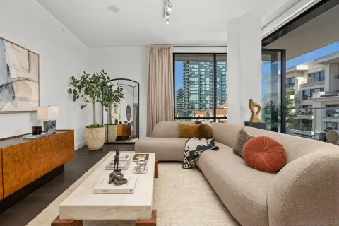 a living room with furniture potted plant and a large window