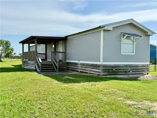 a view of a house with backyard and sitting area