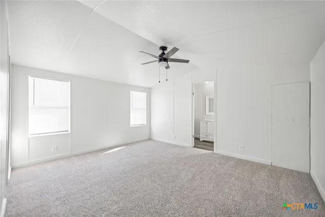 a view of an empty room with a ceiling fan